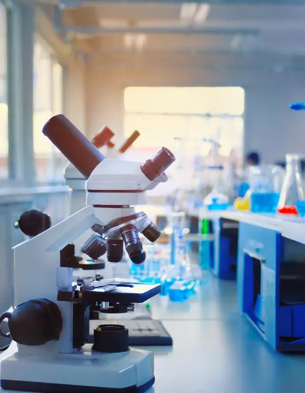 Microscope and glassware on a laboratory bench